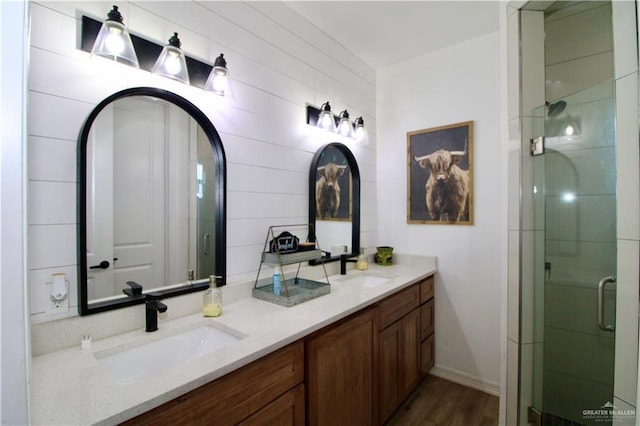 bathroom with vanity, a shower with shower door, and hardwood / wood-style flooring