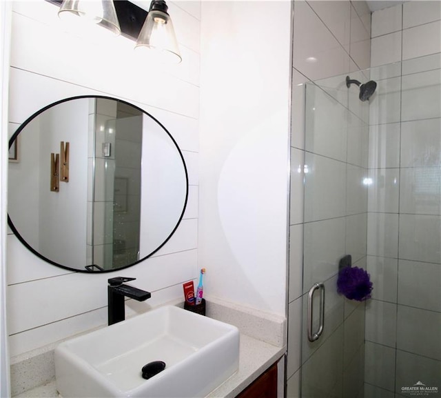 bathroom with a shower with door and vanity