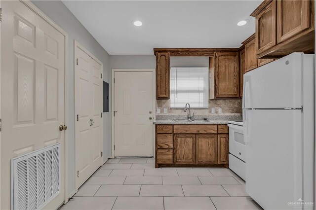 kitchen featuring decorative backsplash, white appliances, sink, light tile patterned floors, and electric panel