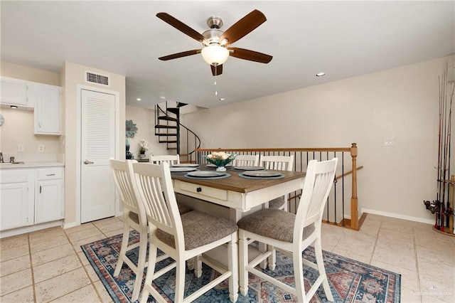 dining room with ceiling fan and sink