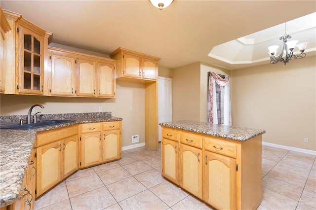 kitchen with a notable chandelier, light tile patterned flooring, light stone countertops, and sink