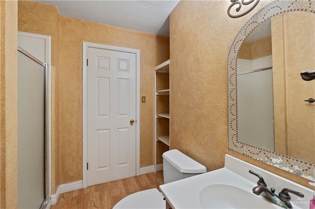 3206 Marion Ct, Harlingen, TX 78550 - full bath with wood finished floors, a shower stall, vanity, and a textured wall