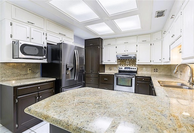 kitchen featuring appliances with stainless steel finishes, sink, white cabinets, and decorative backsplash