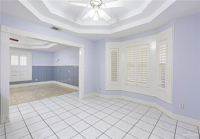 unfurnished room featuring ceiling fan and a raised ceiling