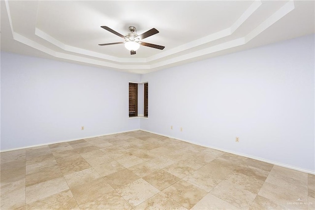 unfurnished room featuring ceiling fan and a tray ceiling