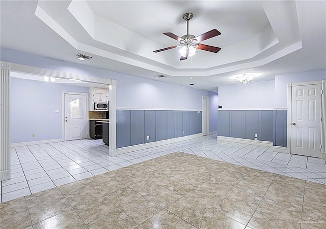 unfurnished room featuring light tile patterned floors, a raised ceiling, and ceiling fan