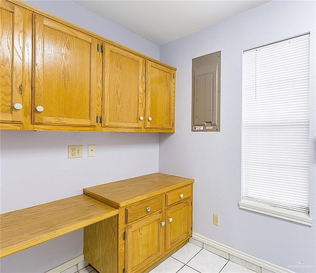 kitchen with built in desk, light tile patterned floors, and electric panel