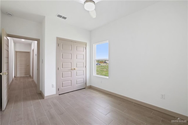 905 E 38th St E, San Juan, TX 78589 - unfurnished bedroom featuring light wood finished floors, a closet, baseboards, and a ceiling fan