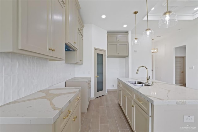 905 E 38th St E, San Juan, TX 78589 - kitchen featuring a sink, backsplash, a kitchen island with sink, pendant lighting, and light stone countertops