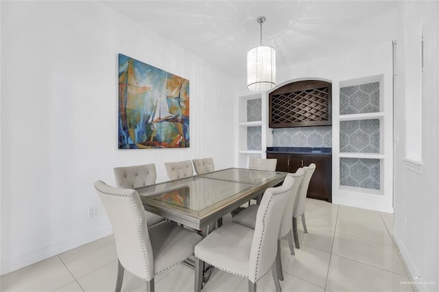 dining area featuring baseboards, an inviting chandelier, and light tile patterned floors