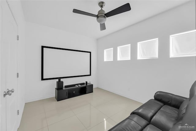 tiled home theater room featuring ceiling fan and baseboards
