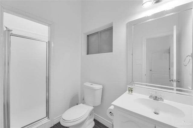 full bath featuring vanity, toilet, baseboards, and a shower stall