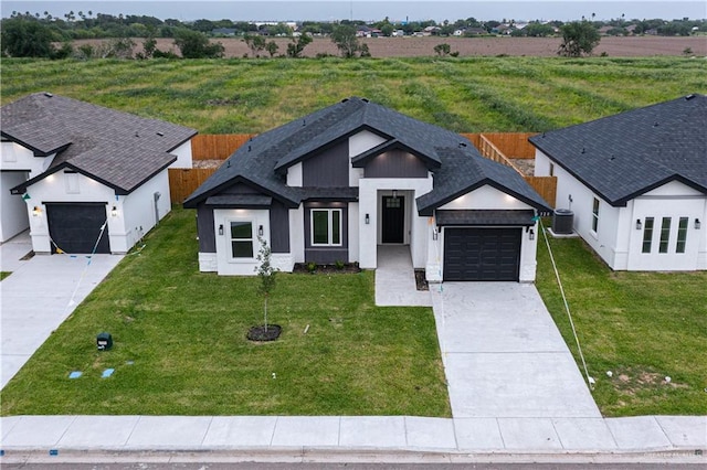 328 N Leon Ave, Elsa, TX 78543 - view of front facade featuring an attached garage, driveway, central AC unit, and roof with shingles