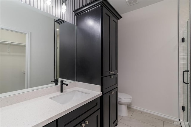 328 N Leon Ave, Elsa, TX 78543 - bathroom with toilet, a stall shower, vanity, tile patterned flooring, and baseboards