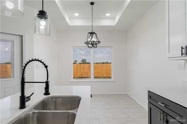 328 N Leon Ave, Elsa, TX 78543 - kitchen featuring a sink, light stone countertops, decorative light fixtures, a raised ceiling, and recessed lighting