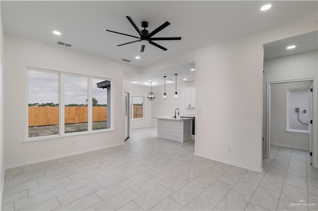 328 N Leon Ave, Elsa, TX 78543 - unfurnished living room with ceiling fan, recessed lighting, a sink, and baseboards