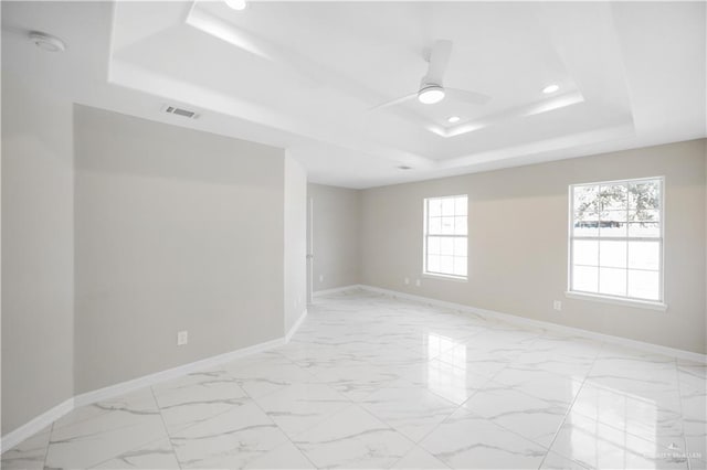 spare room featuring ceiling fan and a tray ceiling