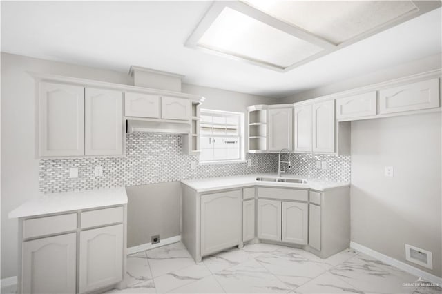 kitchen featuring white cabinets, extractor fan, sink, and backsplash