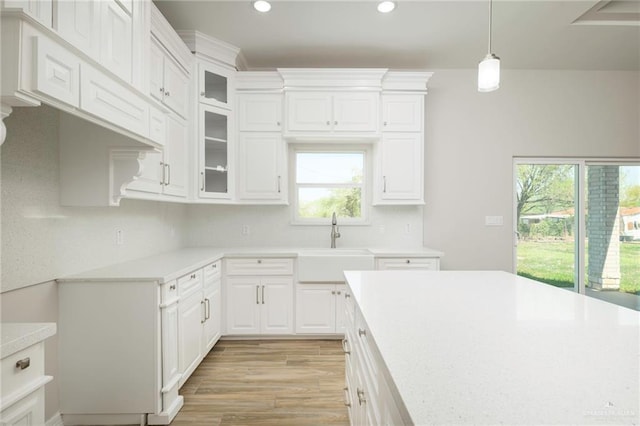 kitchen featuring a sink, light wood-type flooring, light countertops, and white cabinetry