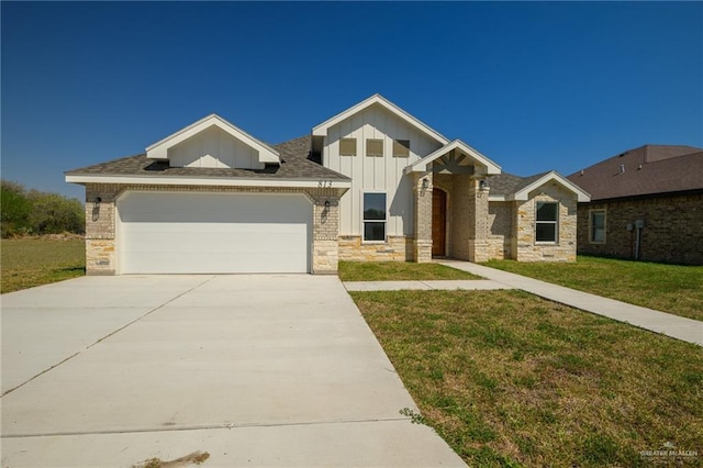 view of front of house with driveway, a front lawn, stone siding, a garage, and board and batten siding