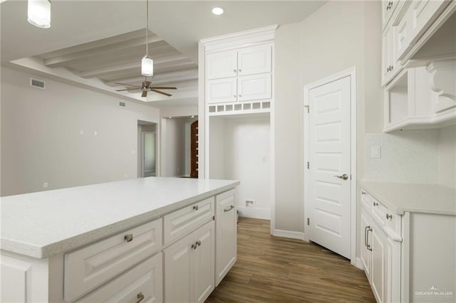 kitchen with a ceiling fan, visible vents, dark wood finished floors, white cabinets, and decorative light fixtures