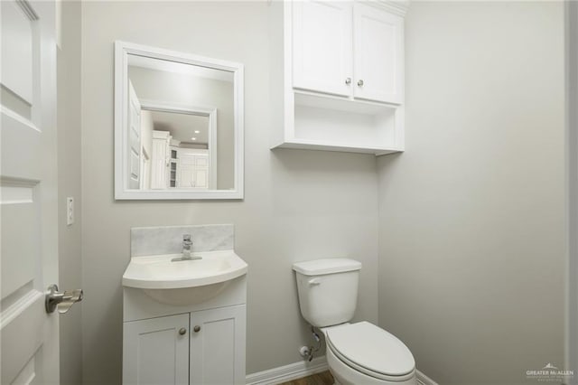 bathroom featuring vanity, toilet, and baseboards