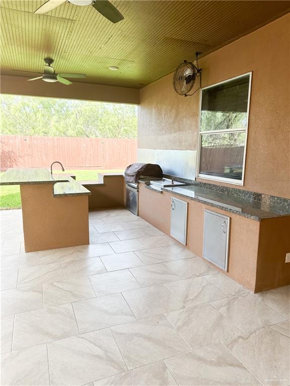 view of patio / terrace with area for grilling, ceiling fan, and a grill