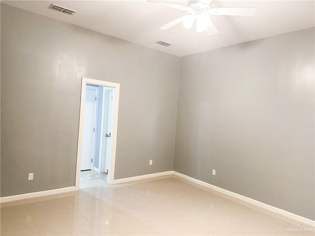 empty room with ceiling fan and light tile patterned floors