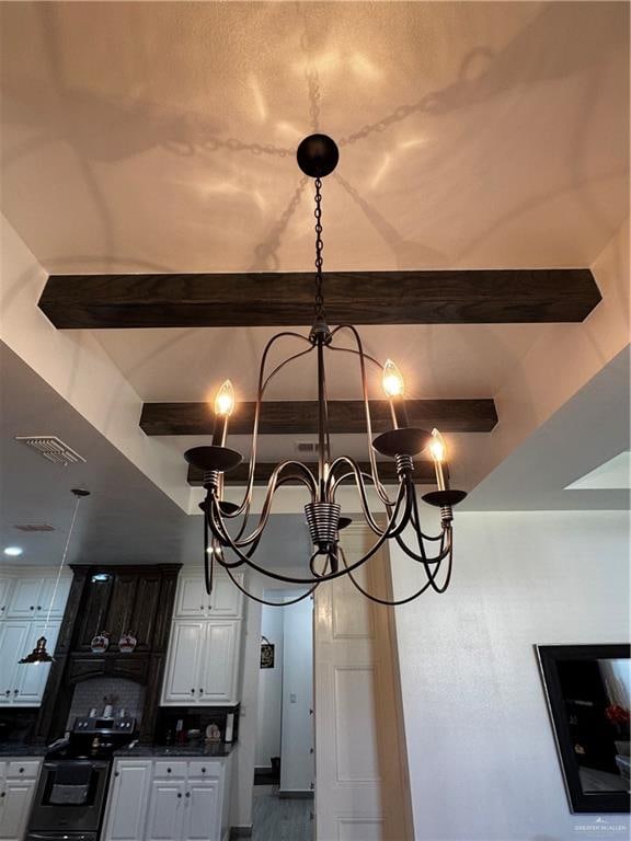 room details featuring stainless steel electric range oven, beamed ceiling, white cabinets, and a chandelier