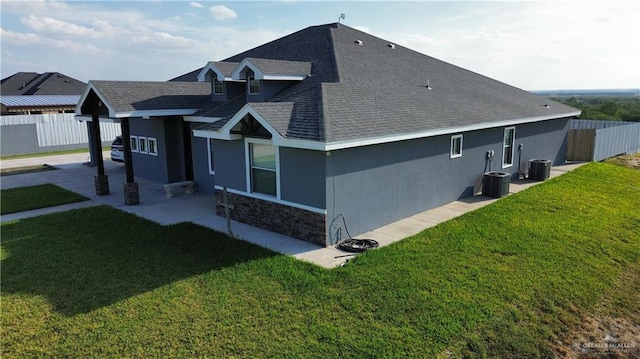 view of side of home with central air condition unit and a lawn