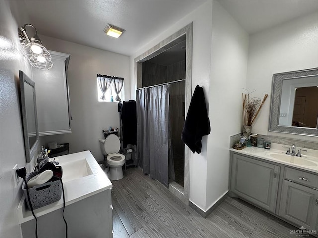 bathroom featuring a shower with shower curtain, vanity, toilet, and wood-type flooring