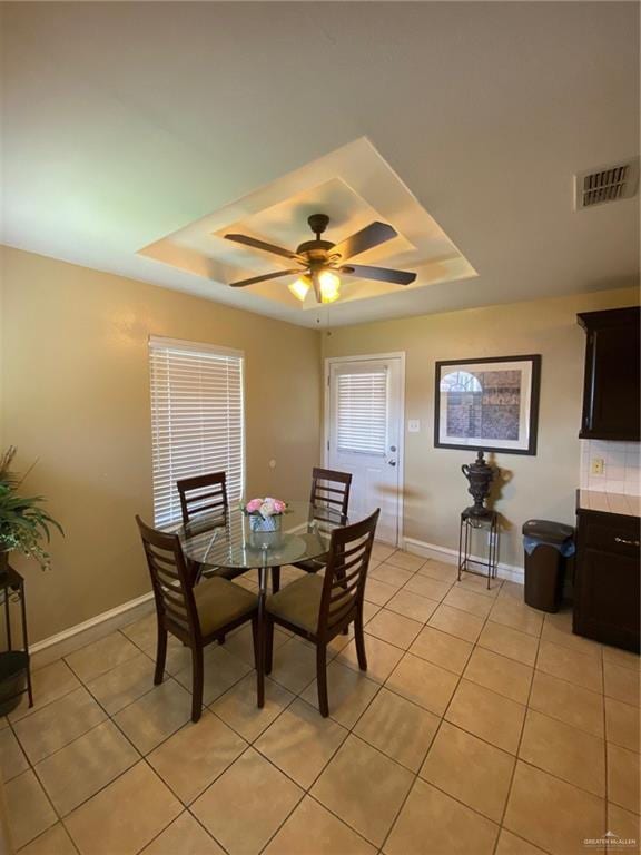 1903 E Llano Grande St, Weslaco, TX 78596 - dining space featuring a raised ceiling, light tile patterned floors, a ceiling fan, and baseboards