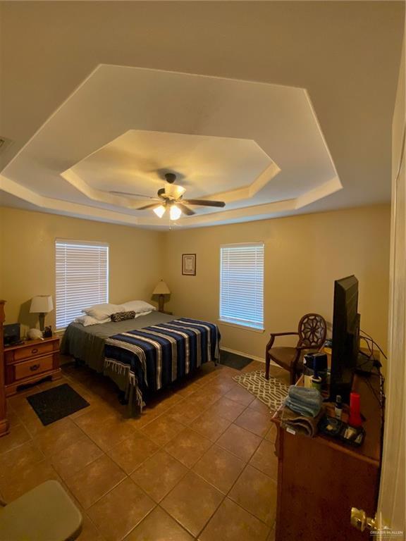 1903 E Llano Grande St, Weslaco, TX 78596 - bedroom featuring a raised ceiling, tile patterned floors, and ceiling fan