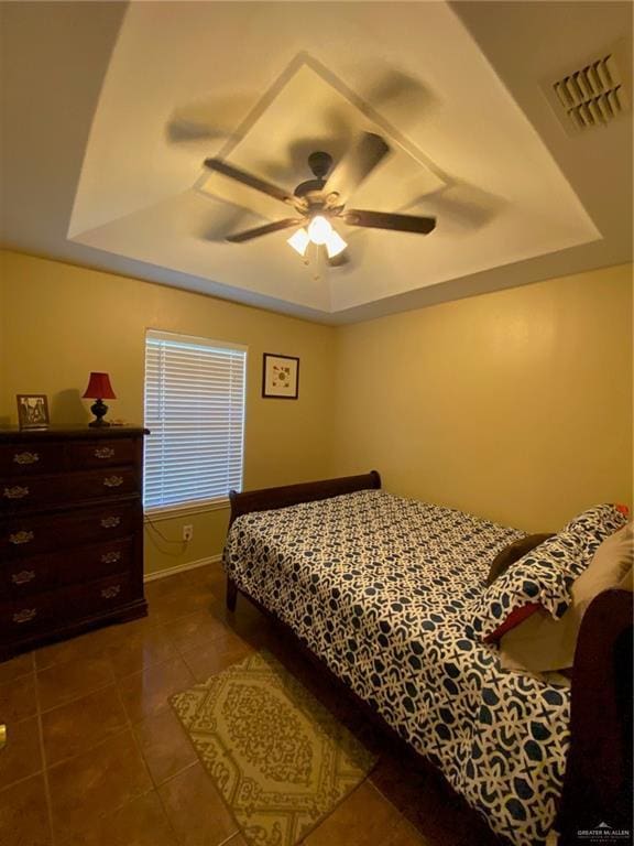 1903 E Llano Grande St, Weslaco, TX 78596 - tiled bedroom featuring a tray ceiling, baseboards, and ceiling fan