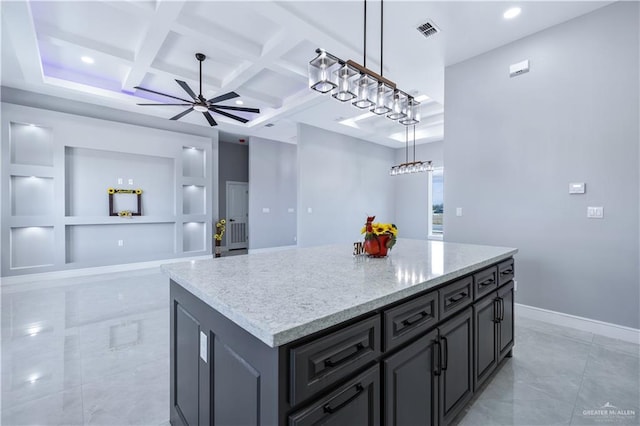 kitchen featuring pendant lighting, ceiling fan, a center island, light stone counters, and coffered ceiling