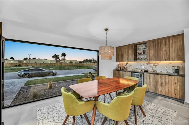 tiled dining room featuring beverage cooler and bar area