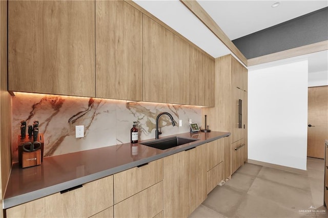 kitchen featuring backsplash, sink, and light brown cabinets