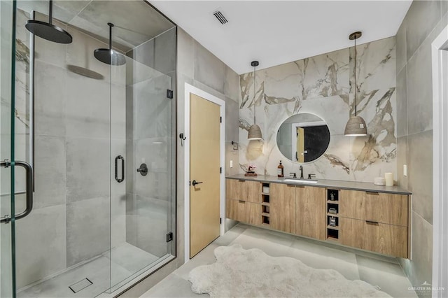 bathroom featuring vanity, an enclosed shower, and tile walls