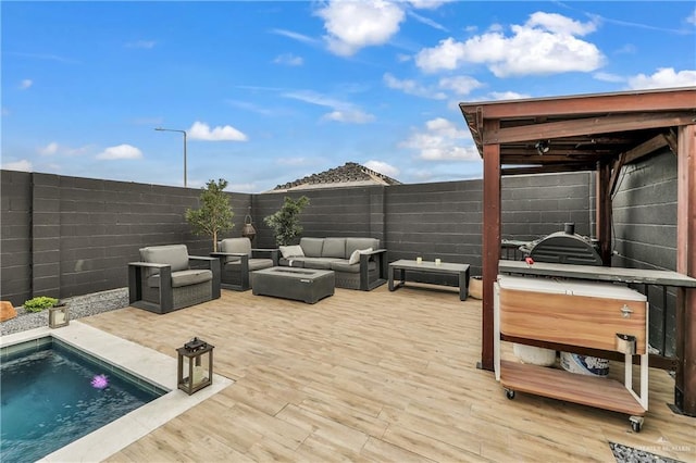 wooden deck featuring a swimming pool with hot tub and an outdoor hangout area