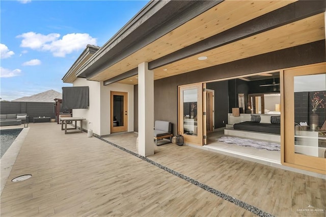 wooden terrace featuring an outdoor hangout area and a patio