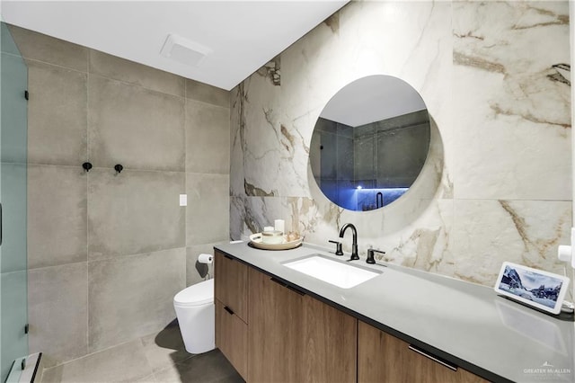 bathroom featuring vanity, toilet, and tile walls