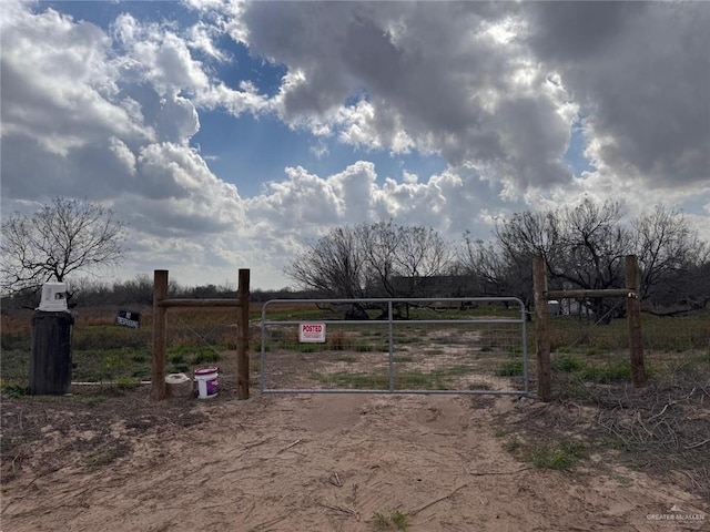 view of yard featuring a gate, a rural view, and fence