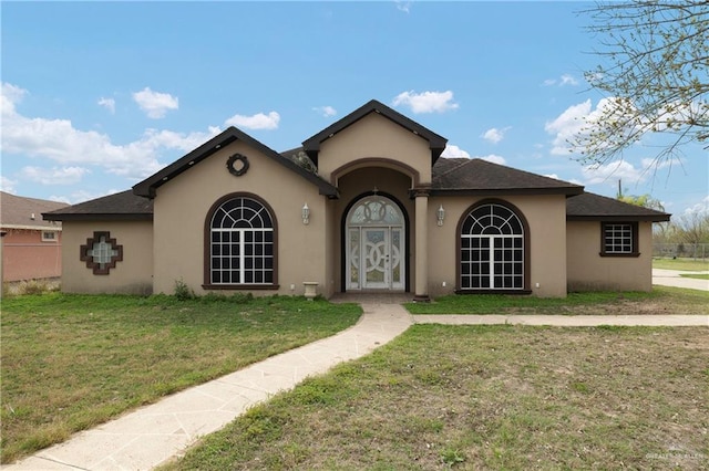 mediterranean / spanish-style home featuring a front lawn and stucco siding