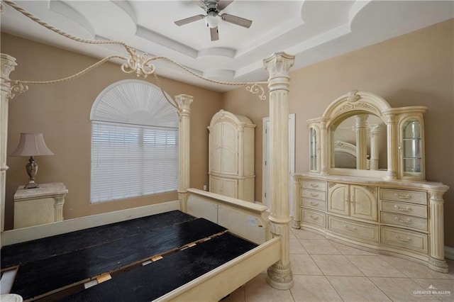 interior space with decorative columns, a raised ceiling, ceiling fan, tile patterned floors, and vanity