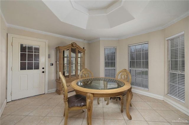 dining area with baseboards, ornamental molding, a raised ceiling, and light tile patterned flooring