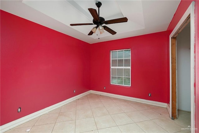 unfurnished room with tile patterned flooring, a ceiling fan, and baseboards