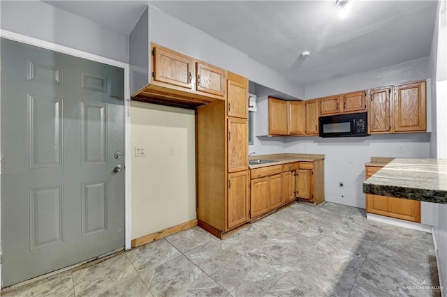 1619 Beech Ave, Mercedes, TX 78570 - kitchen featuring black microwave, a sink, and brown cabinetry