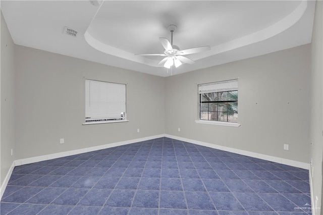 1619 Beech Ave, Mercedes, TX 78570 - unfurnished room featuring a raised ceiling, dark tile patterned flooring, a ceiling fan, and baseboards