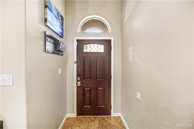 doorway to outside featuring baseboards