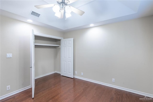 unfurnished bedroom with dark hardwood / wood-style flooring, a closet, and ceiling fan